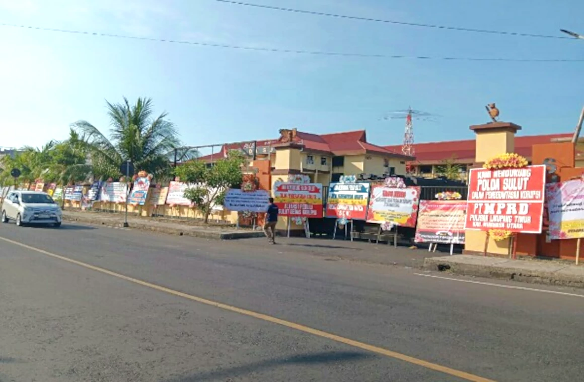 Karangan bunga dari berbagai komponen masyarakat, terpampang di sepanjang pagar Mapolda Sulut yang berada di Jalan Bethesda Nomor 62, Manado. Karangan-karangan bunga berbagai ukuran ini sebagai bentuk dukungan masyarakat terhadap upaya Polda Sulut untuk pemberantasan korupsi.